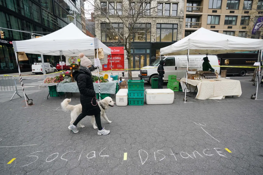„Soziale Distanz“ für Käufer mit Kreide auf den Bürgersteig geschrieben.
